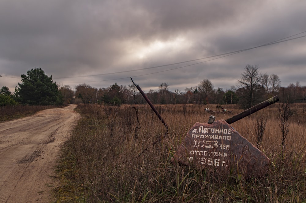 a sign on a dirt road