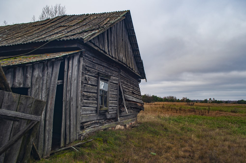 a wooden building in a field