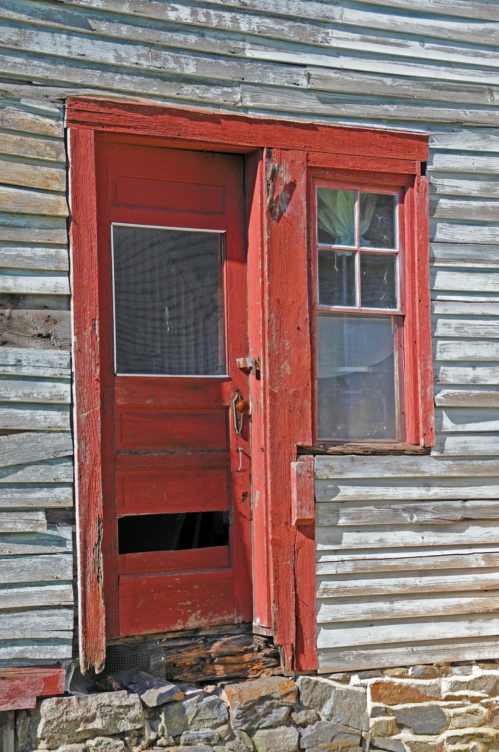 eine rote Tür an einem Holzgebäude