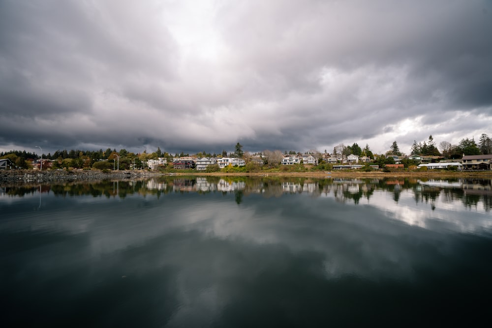 a body of water with buildings and trees in the background