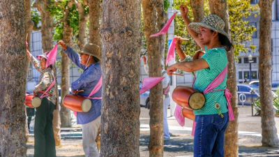 Children and families participating in a colorful fundraising walk in a sunny park.