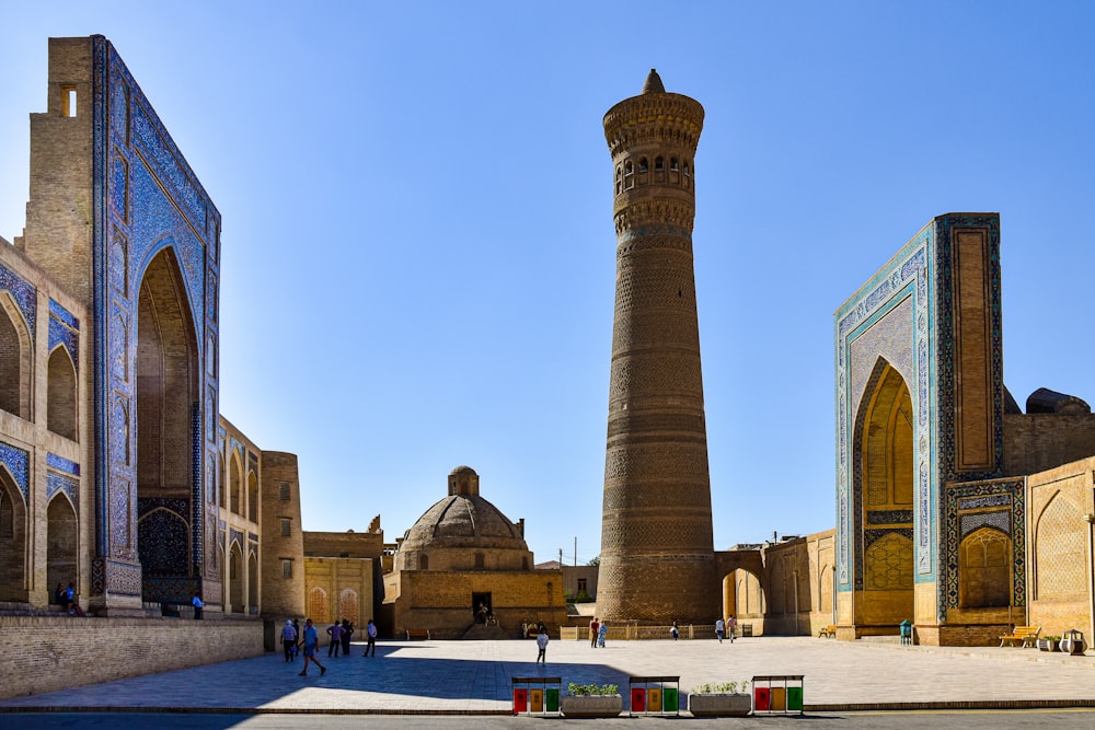 a group of people walking around a large building with towers