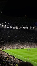 A vibrant stadium under night lights with fans watching an intense football match.