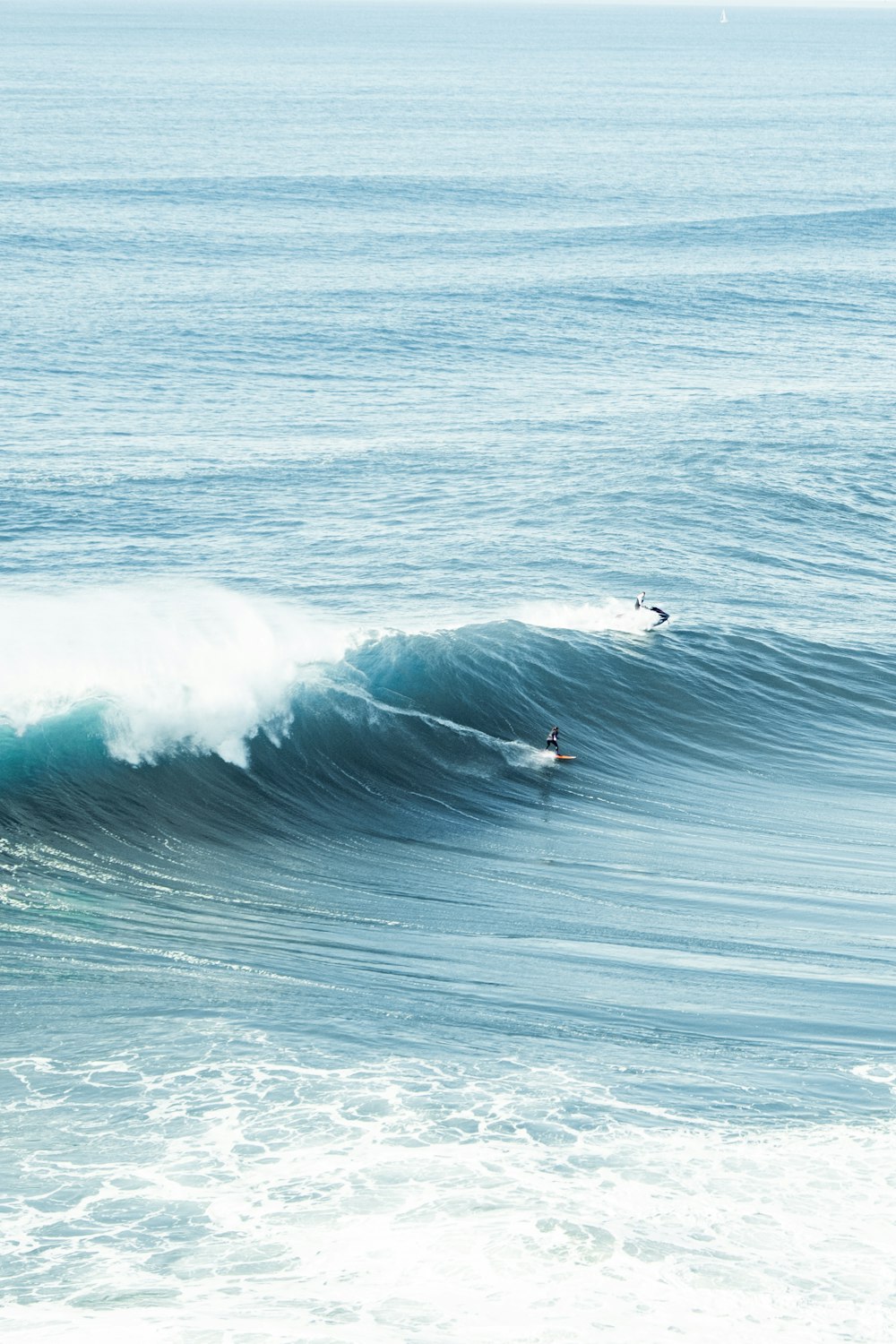 a couple of people surfing on the waves