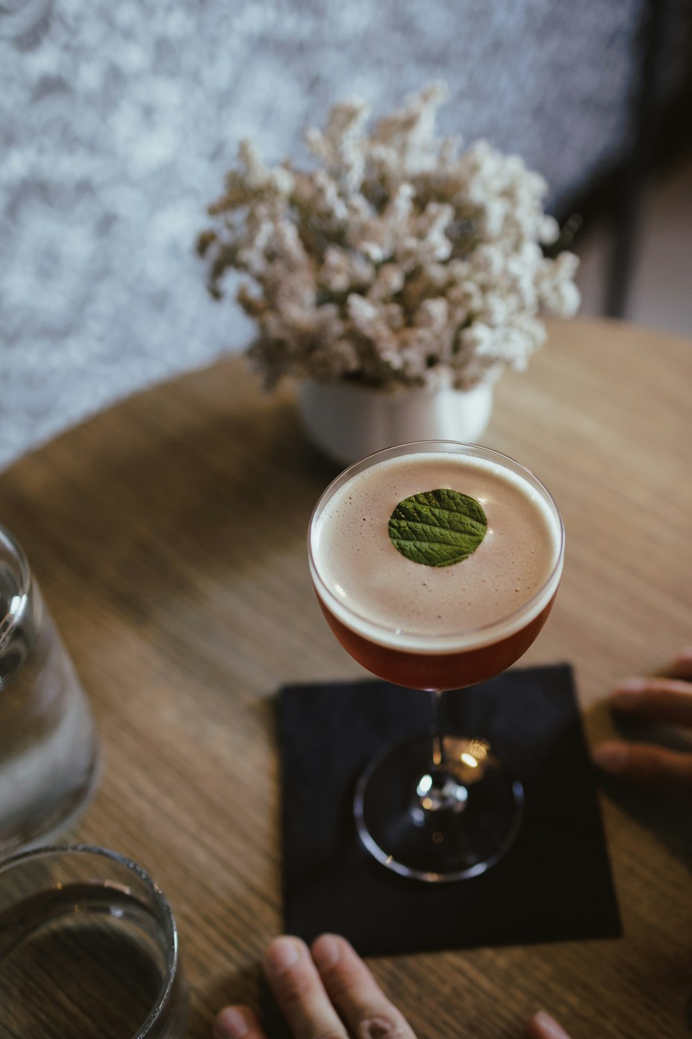 a glass of liquid with a plant in it