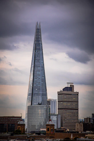 a tall glass building with The Shard in the background