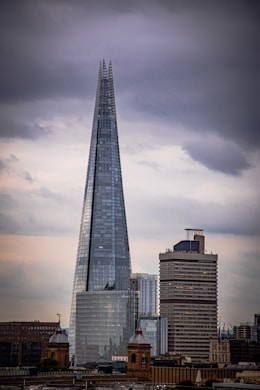 a tall glass building with The Shard in the background