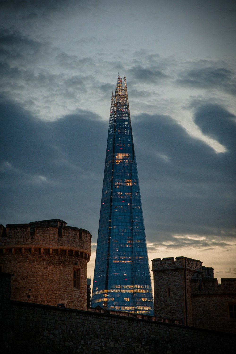 a tall glass building with The Shard in the background