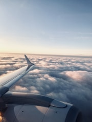 A scenic view of an airplane flying above the clouds.