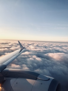 A sleek Ethiopian Airlines aircraft soaring above the clouds with a clear blue sky backdrop
