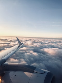 A scenic view of an airplane flying above the clouds.