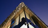 Wide view of security cameras installed on modern office building corners during sunset.