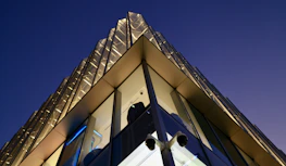 Security cameras monitoring a sleek, modern office building at dusk.