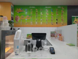 Colorful ice cream scoops and fresh fruit juices displayed on a sunny cafe counter.