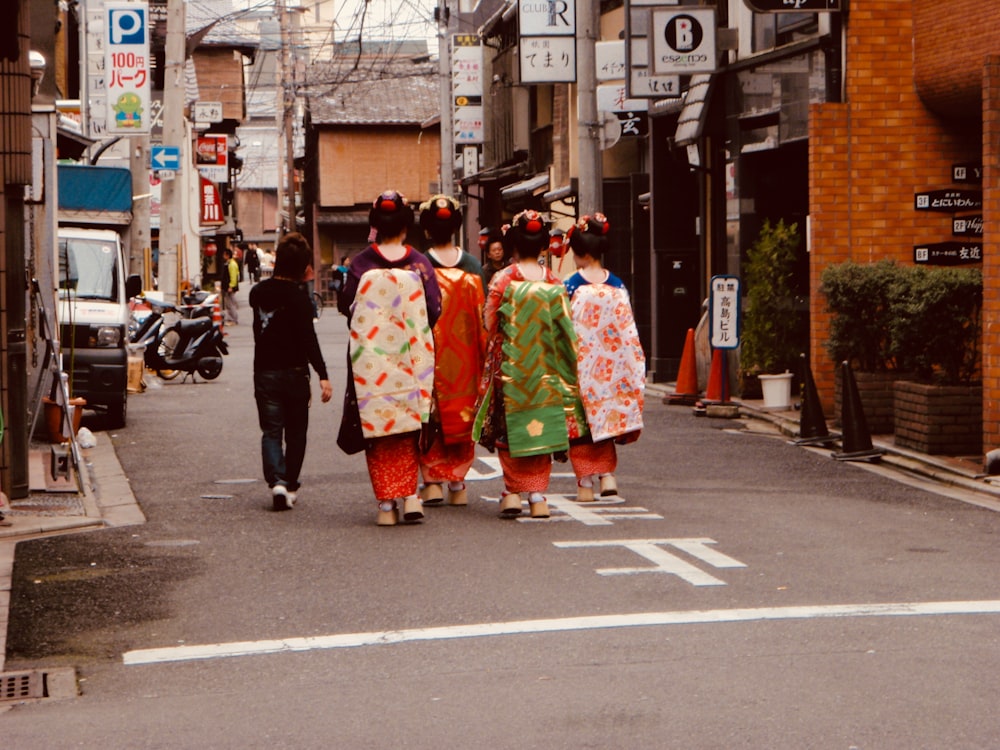 a group of people in traditional dress walking down a street