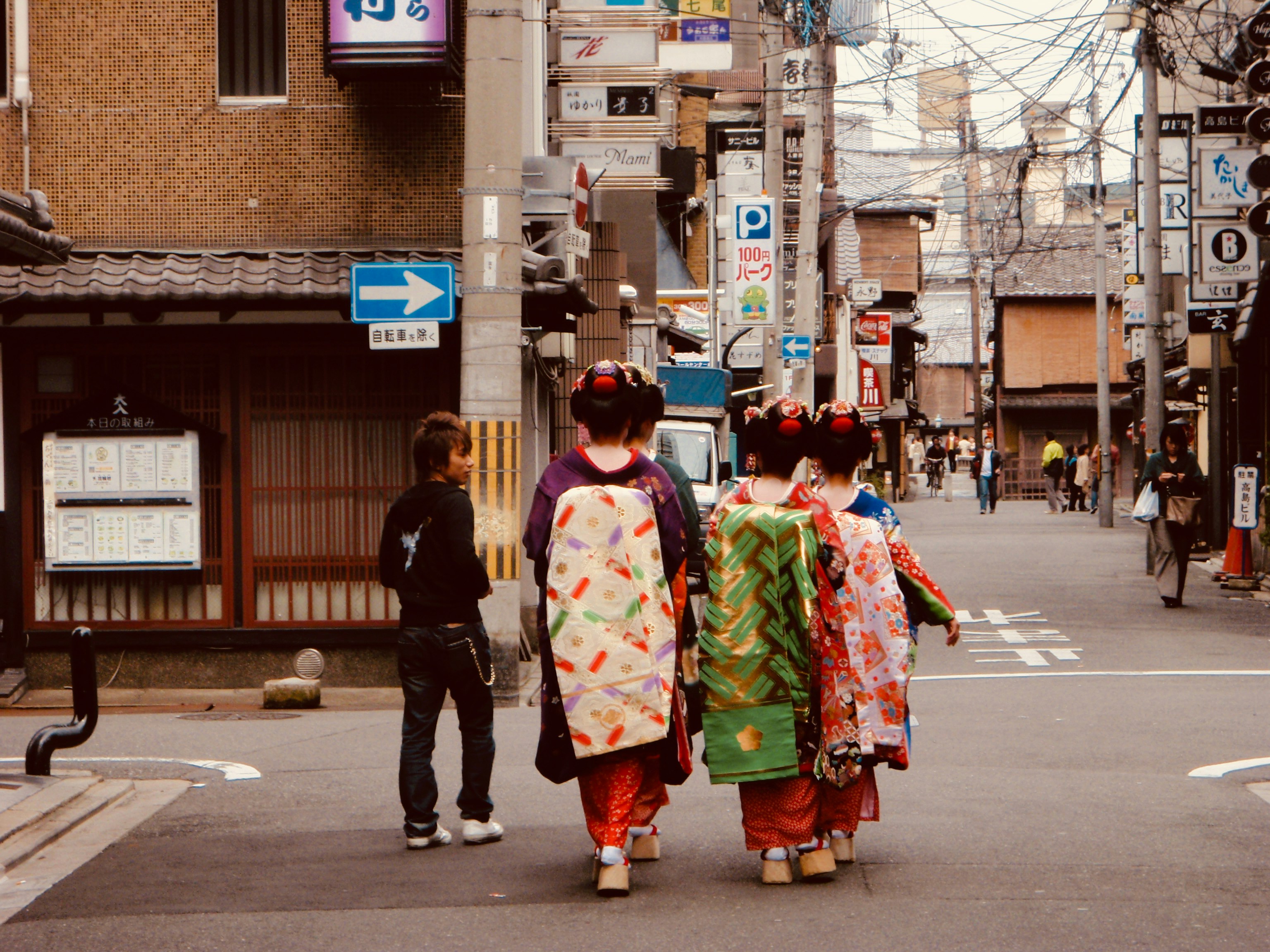 a group of people in traditional dress walking down a street