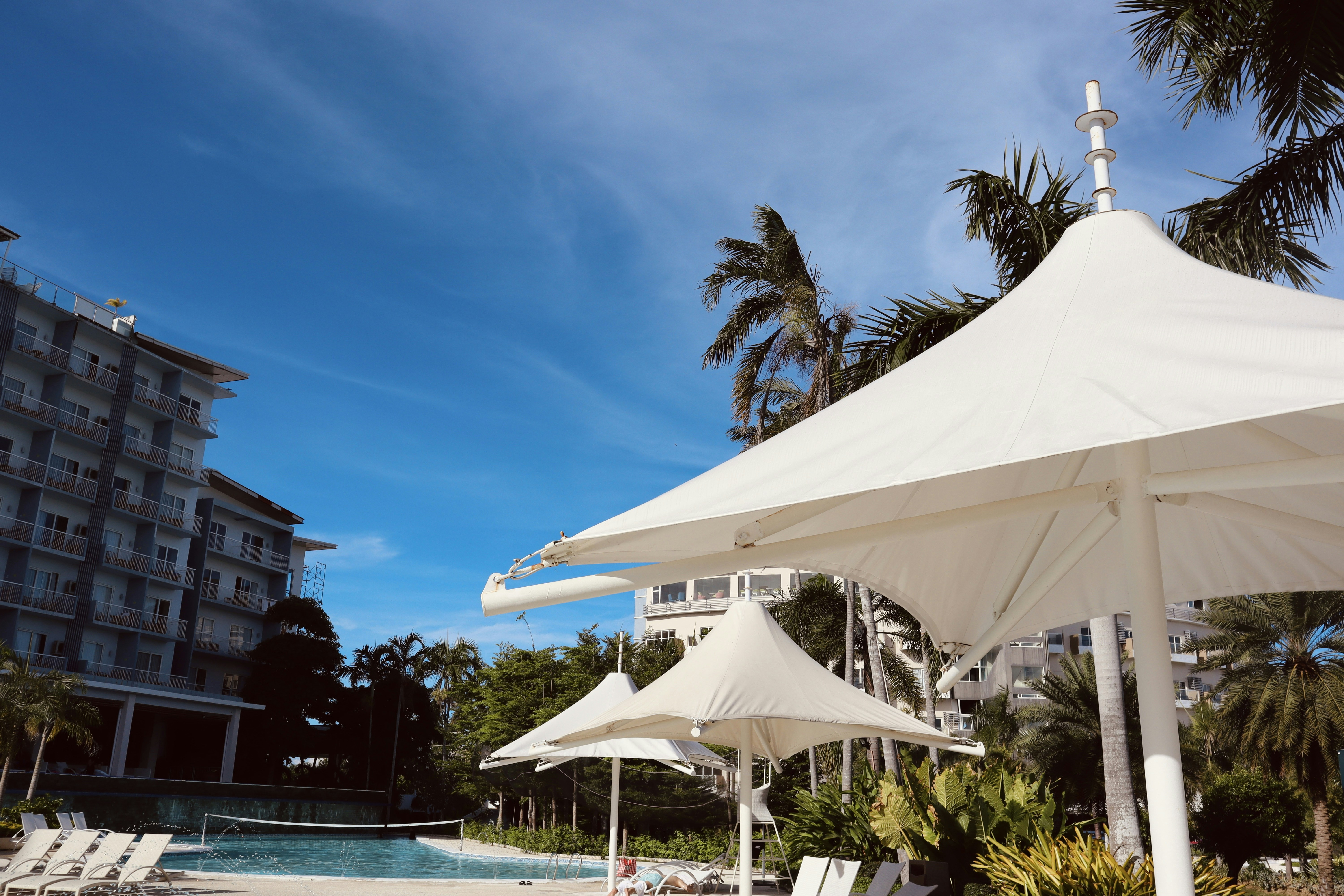 a pool with a white tent and a building in the background