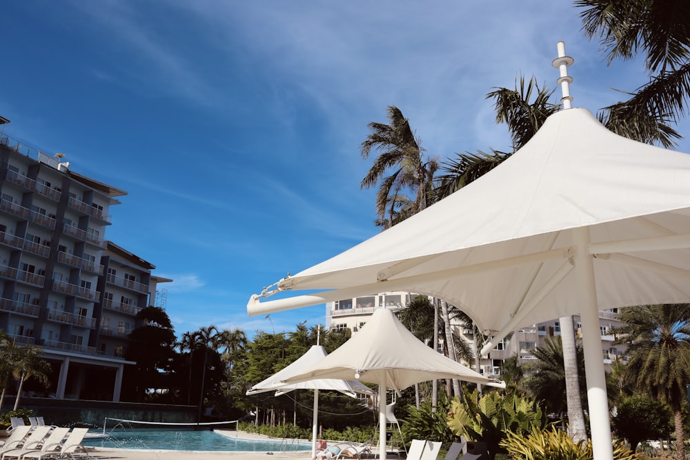 a pool with a white tent and a building in the background