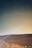 A serene desert landscape under a starry night sky with soft glowing mineral springs.