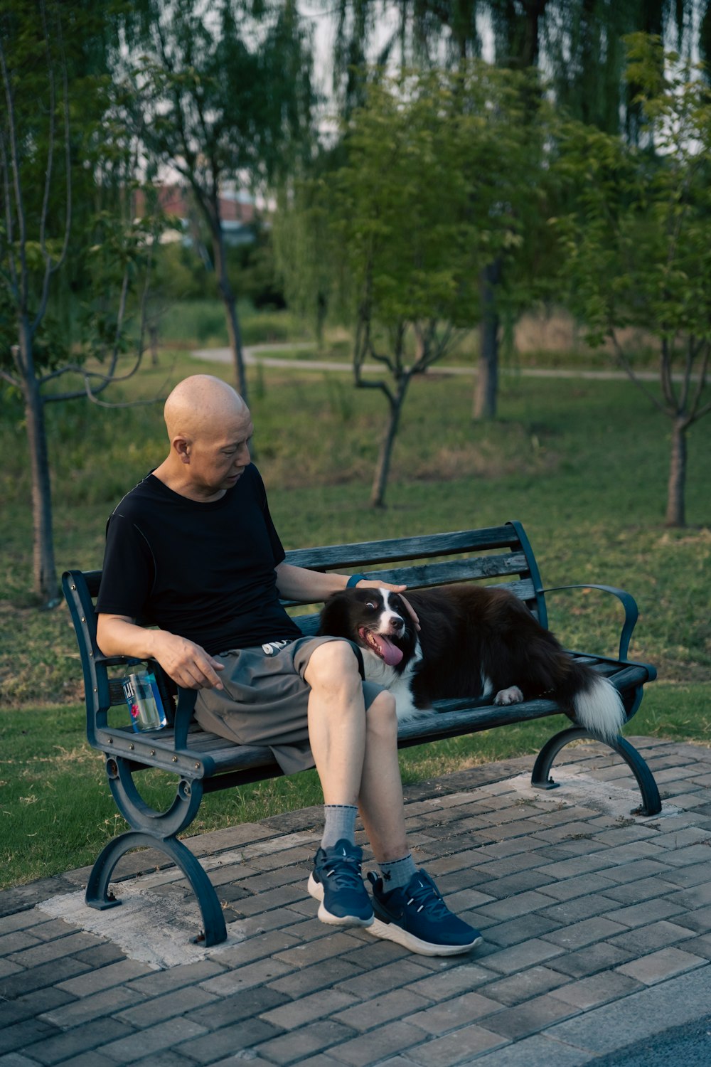 um homem sentado em um banco com um cão