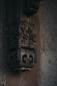 A close-up of a carved wooden wall hanging with intricate details and soft natural lighting.
