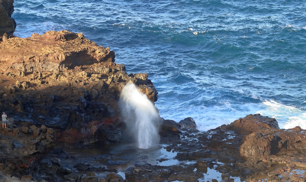 a rocky beach with a body of water in the background