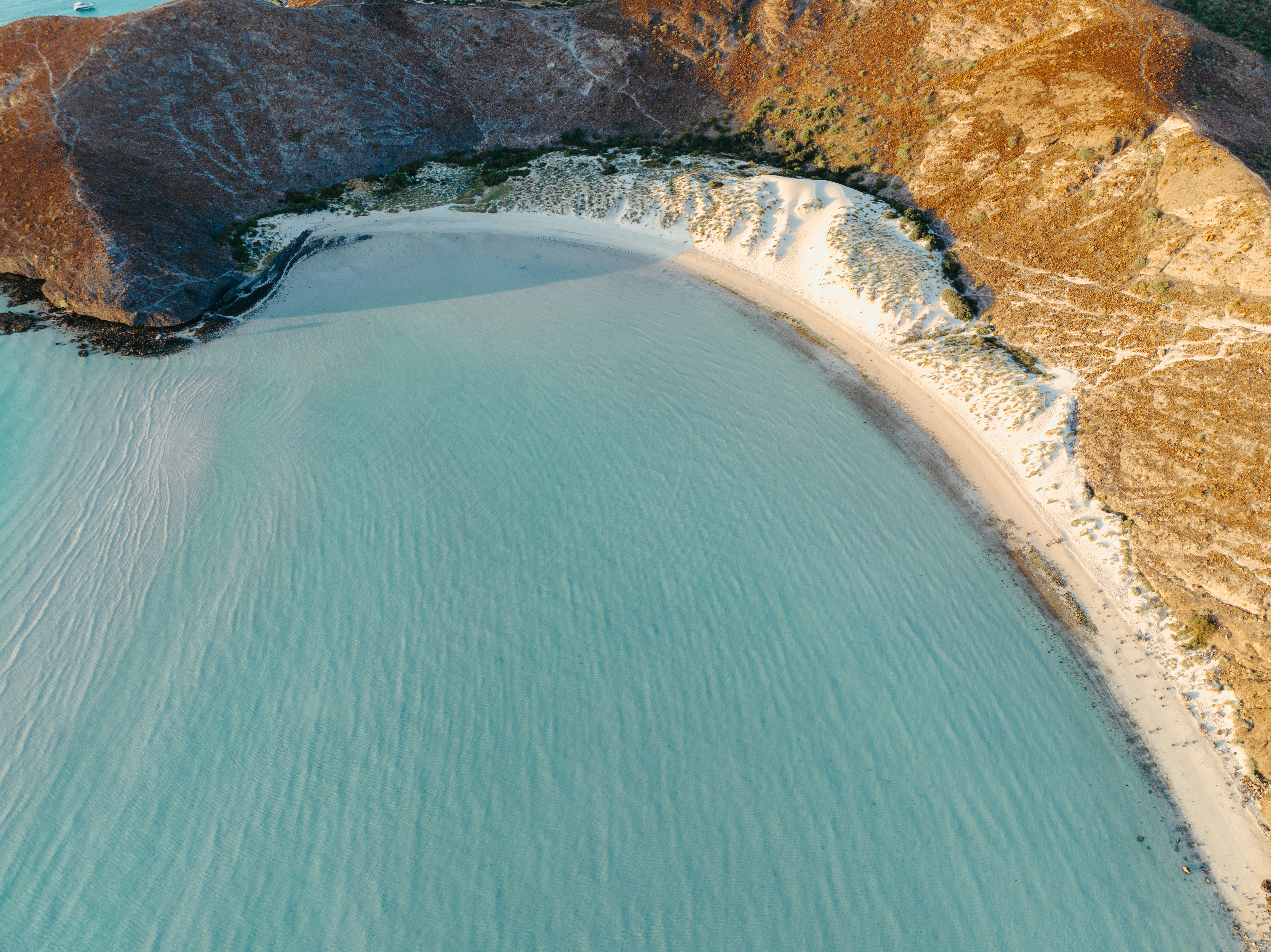 a body of water with a rocky shoreline, 
