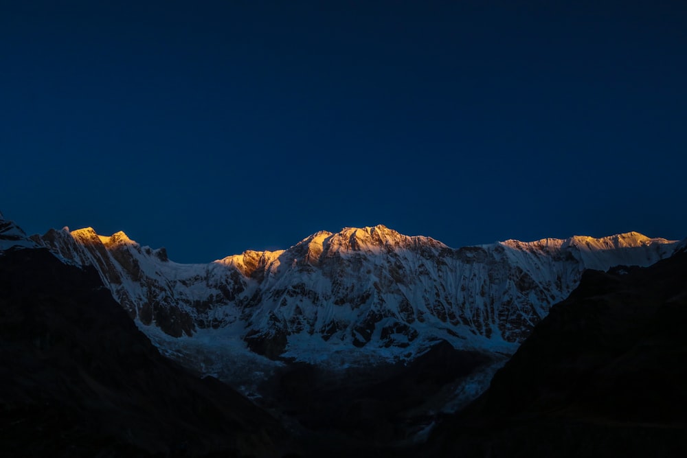 a snowy mountain with a blue sky