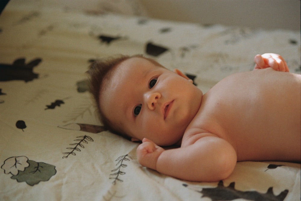 a baby lying on a bed