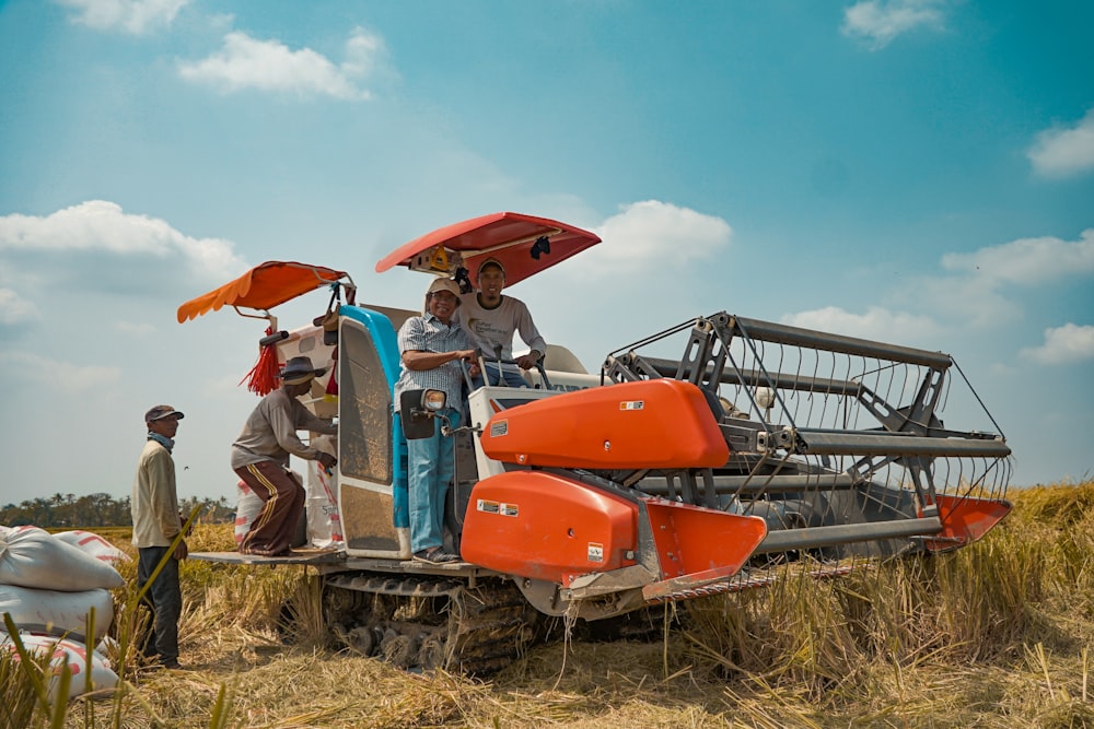 Eine Gruppe von Menschen, die neben einem Traktor auf einem Feld stehen