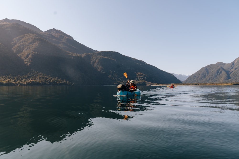 Un grupo de personas en un bote azul en un lago