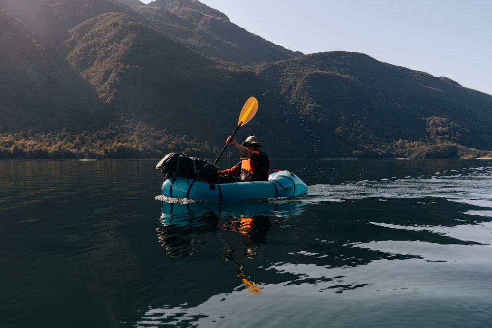 a man and a dog in a kayak on a lake