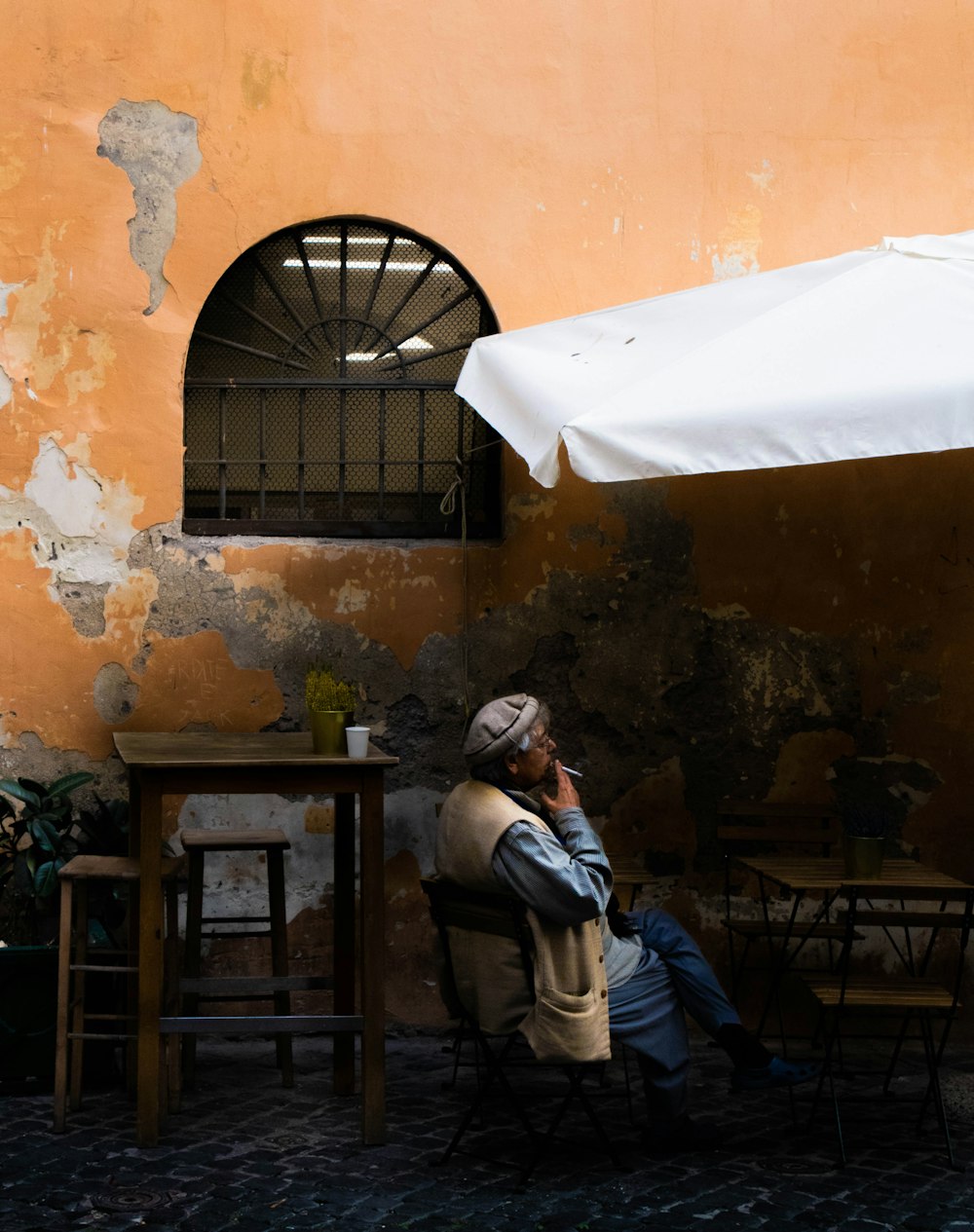 a man sitting under an umbrella