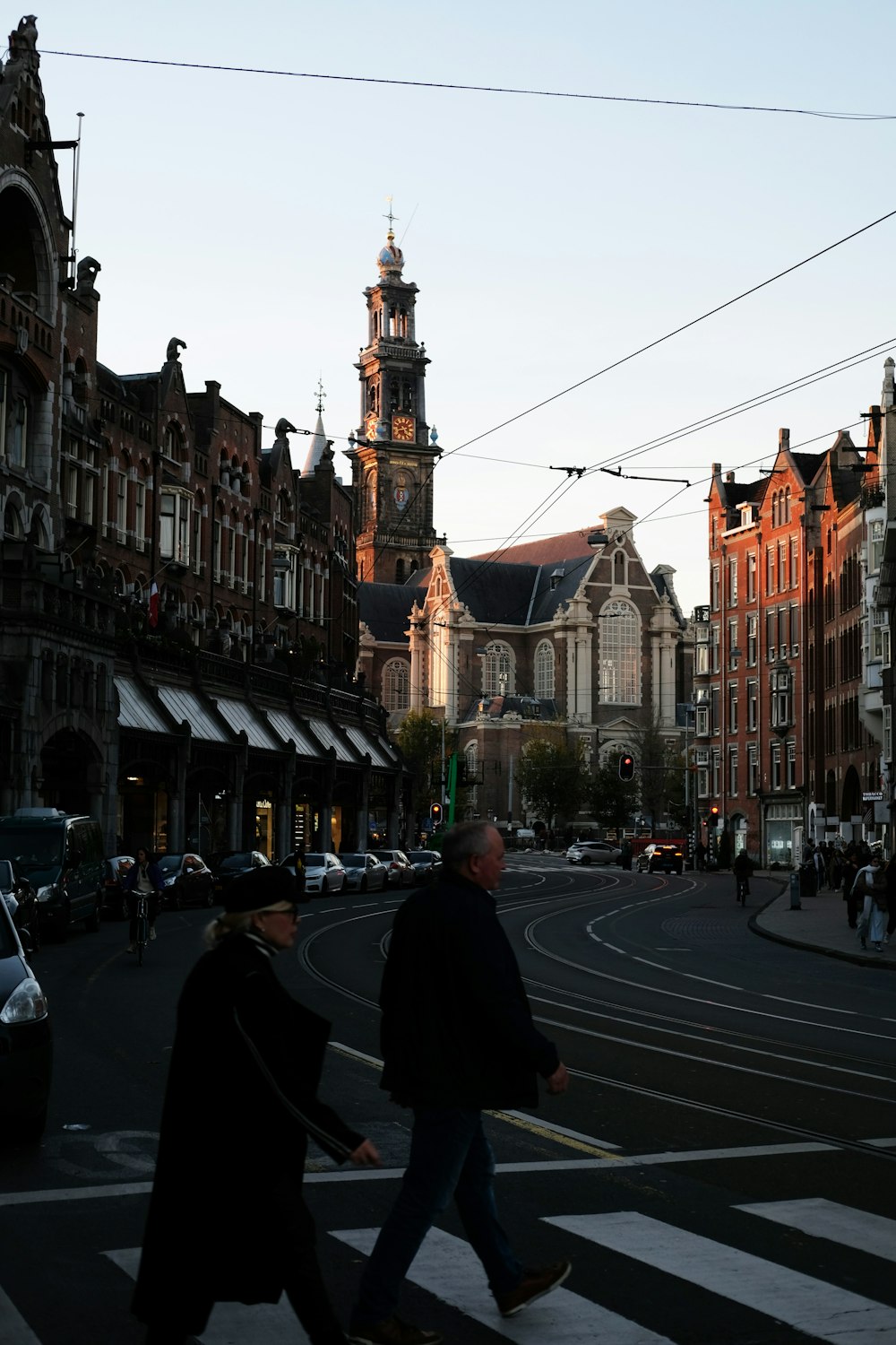 a man and woman walking across a crosswalk in a city