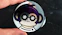 a hand holding a black and purple object with a cartoon face