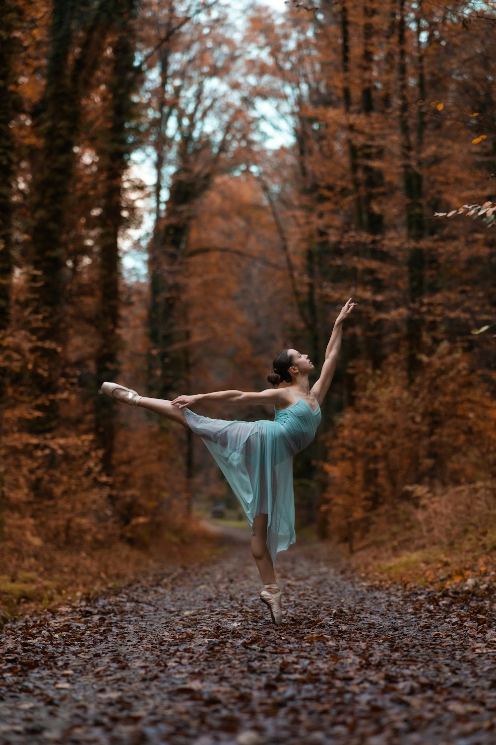 a person in a blue dress dancing in the woods