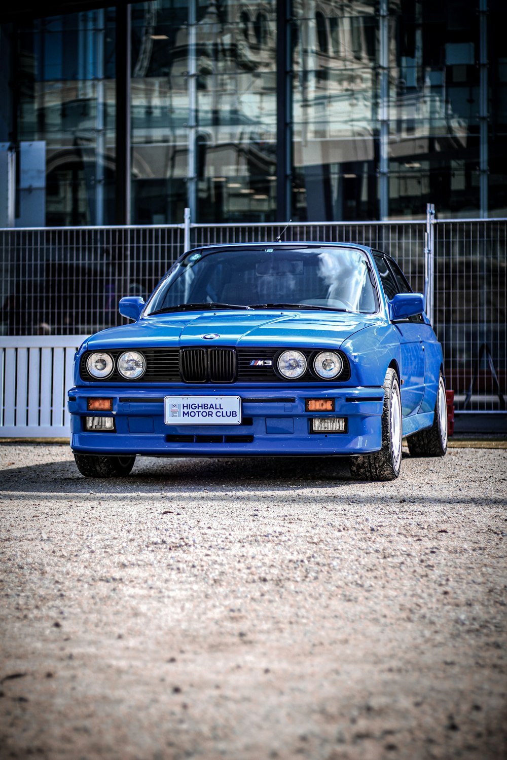 a blue car parked in front of a building