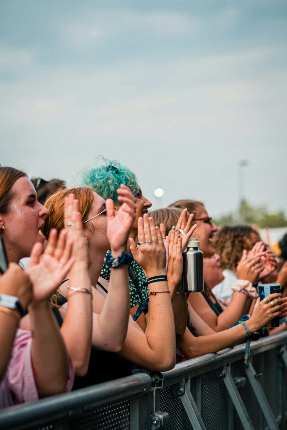 a crowd of people holding their hands up