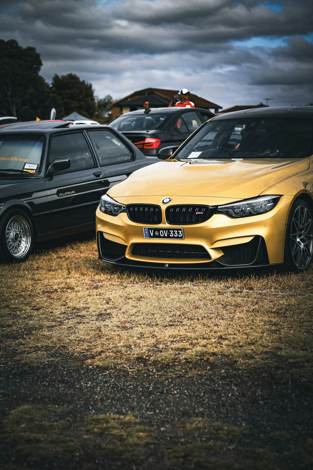 a yellow sports car parked next to other cars