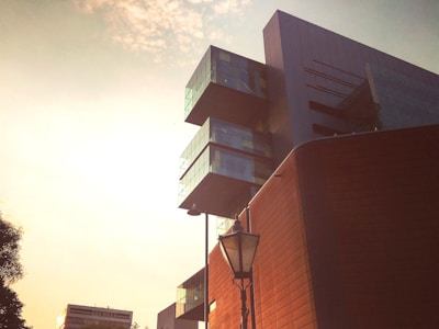 Modern architectural building with glass facade at sunset.