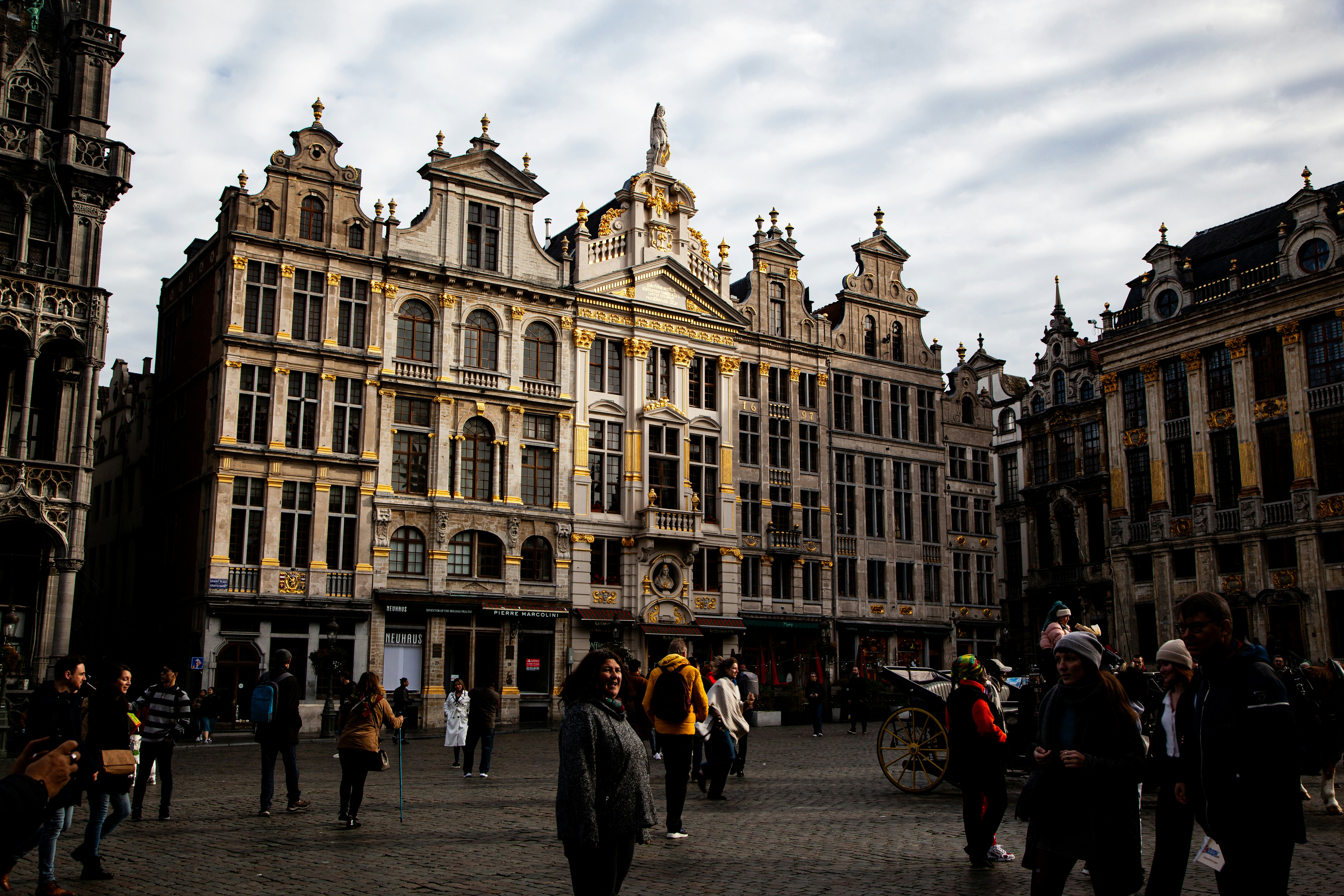 a group of people walking in front of Grand Place, 
