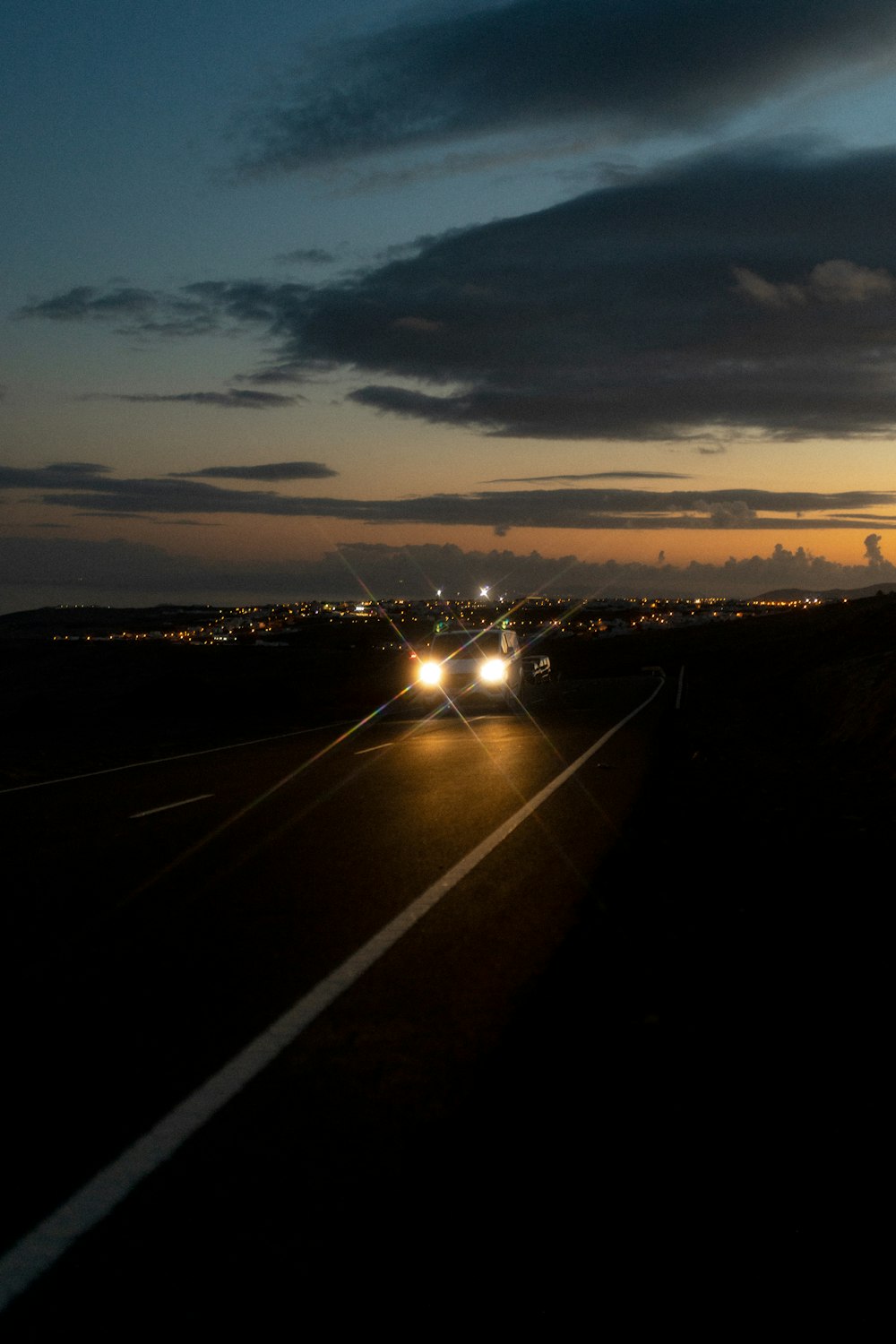 a road with cars on it and a sunset in the background