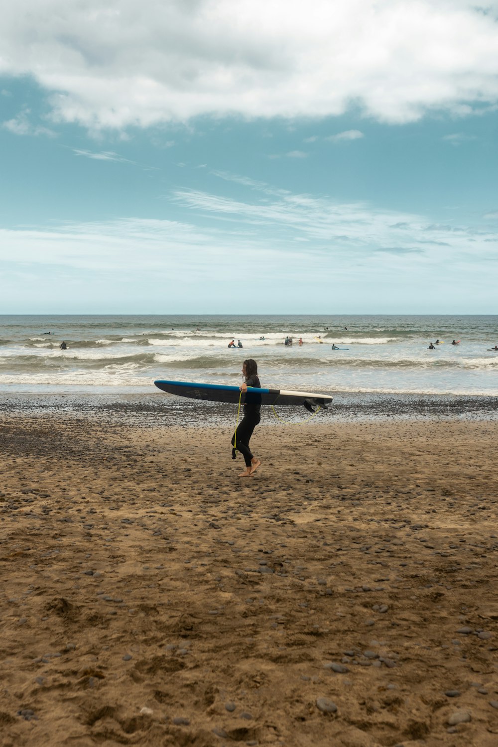 a man carrying a surfboard on a beach