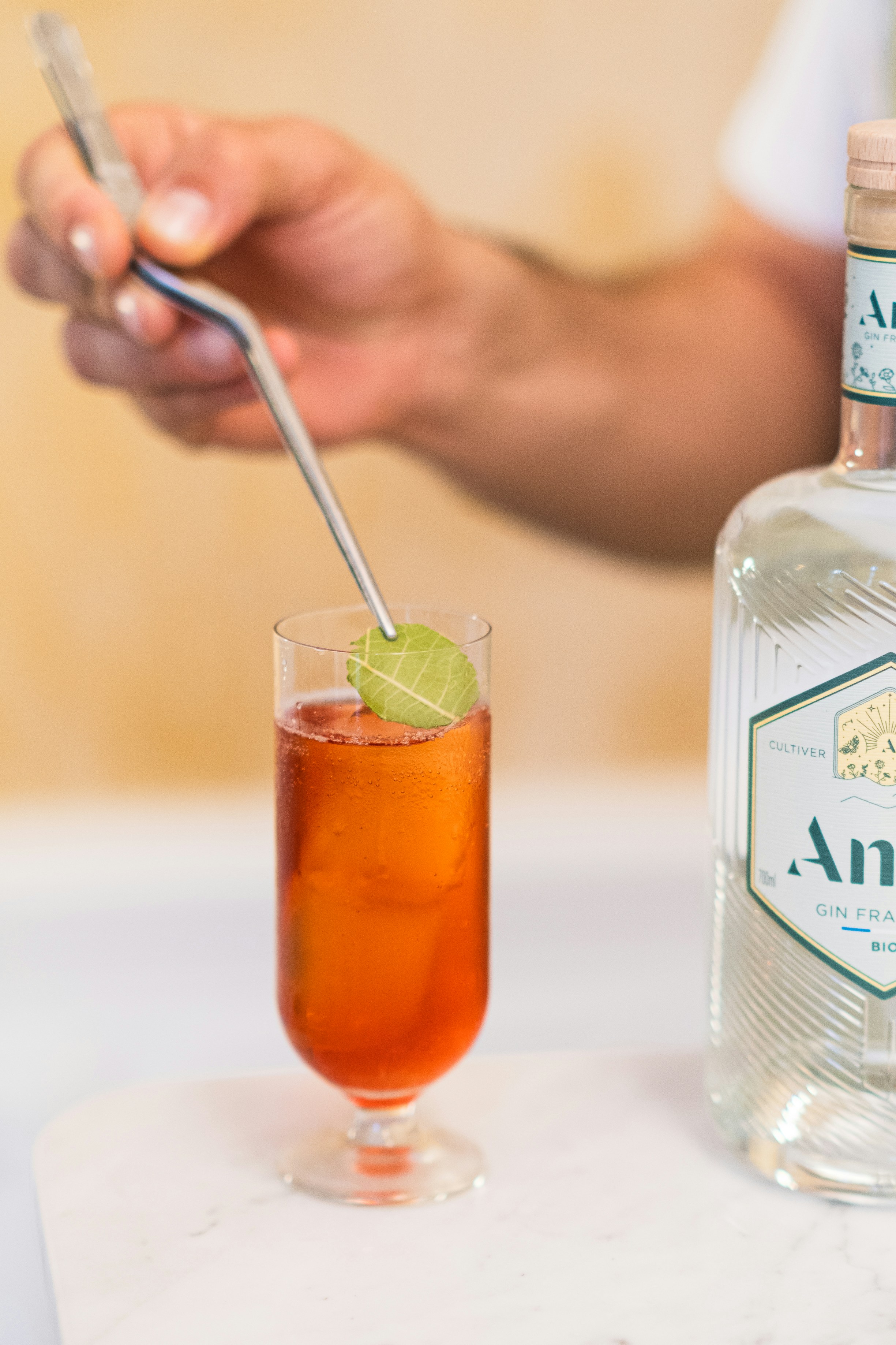 a person holding a glass of liquid