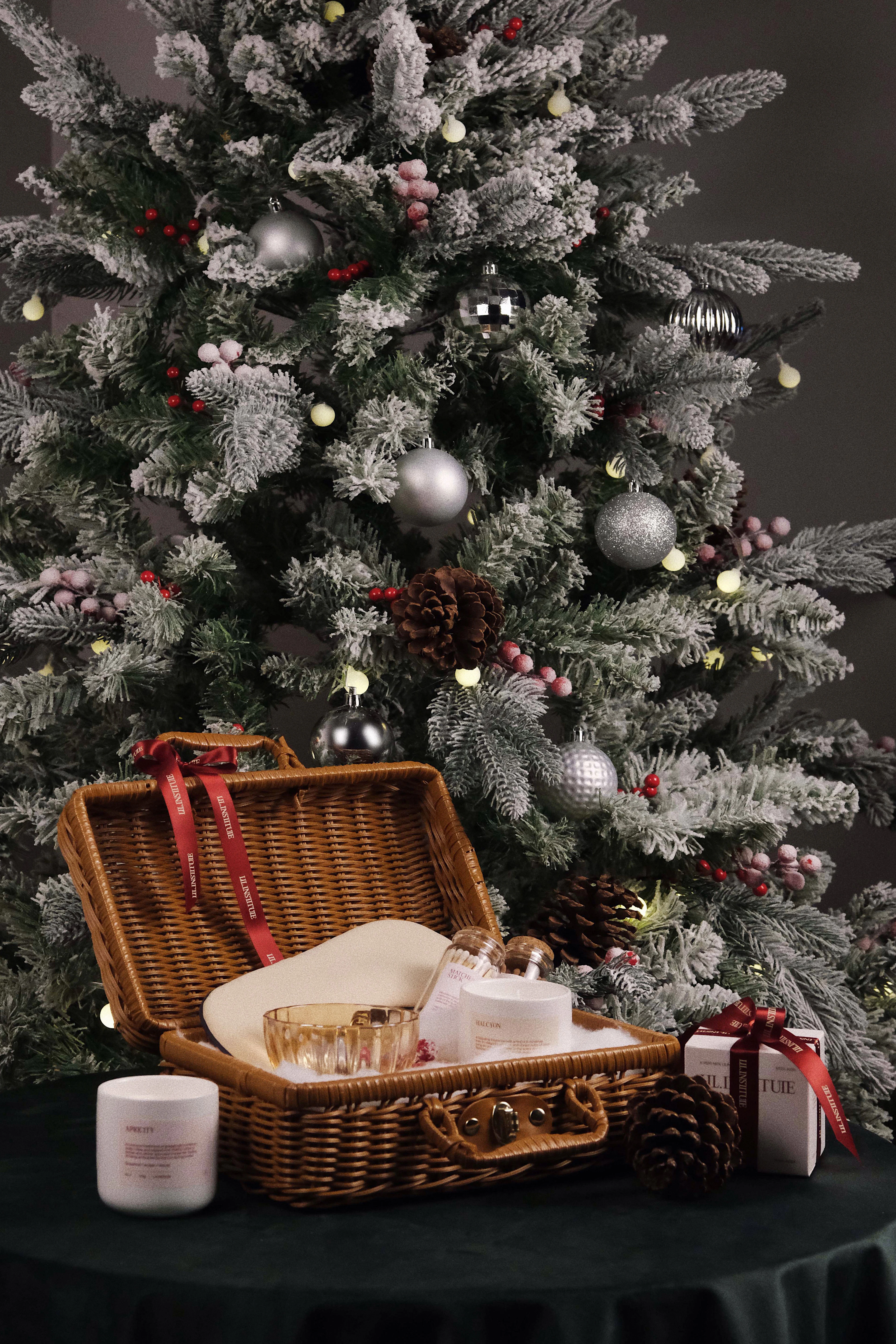 A gift hamper beside a Christmas tree