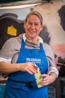 A smiling customer holding a shopping bag filled with chlesda food products.