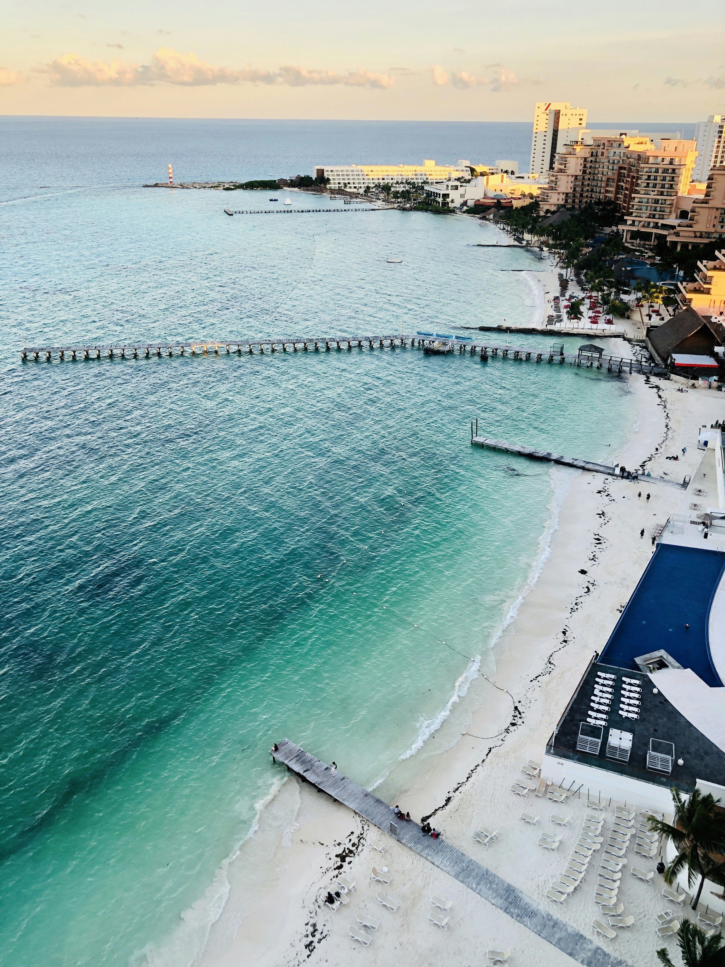 Spiaggia di Cancun con acqua caraibica cristallina sabbia bianca e resort al tramonto