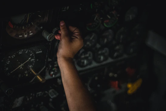 Close-up of hands adjusting HVAC system controls in an industrial environment.