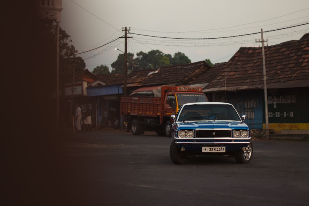 a blue car driving down a street