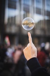 a hand holding a glass of liquid